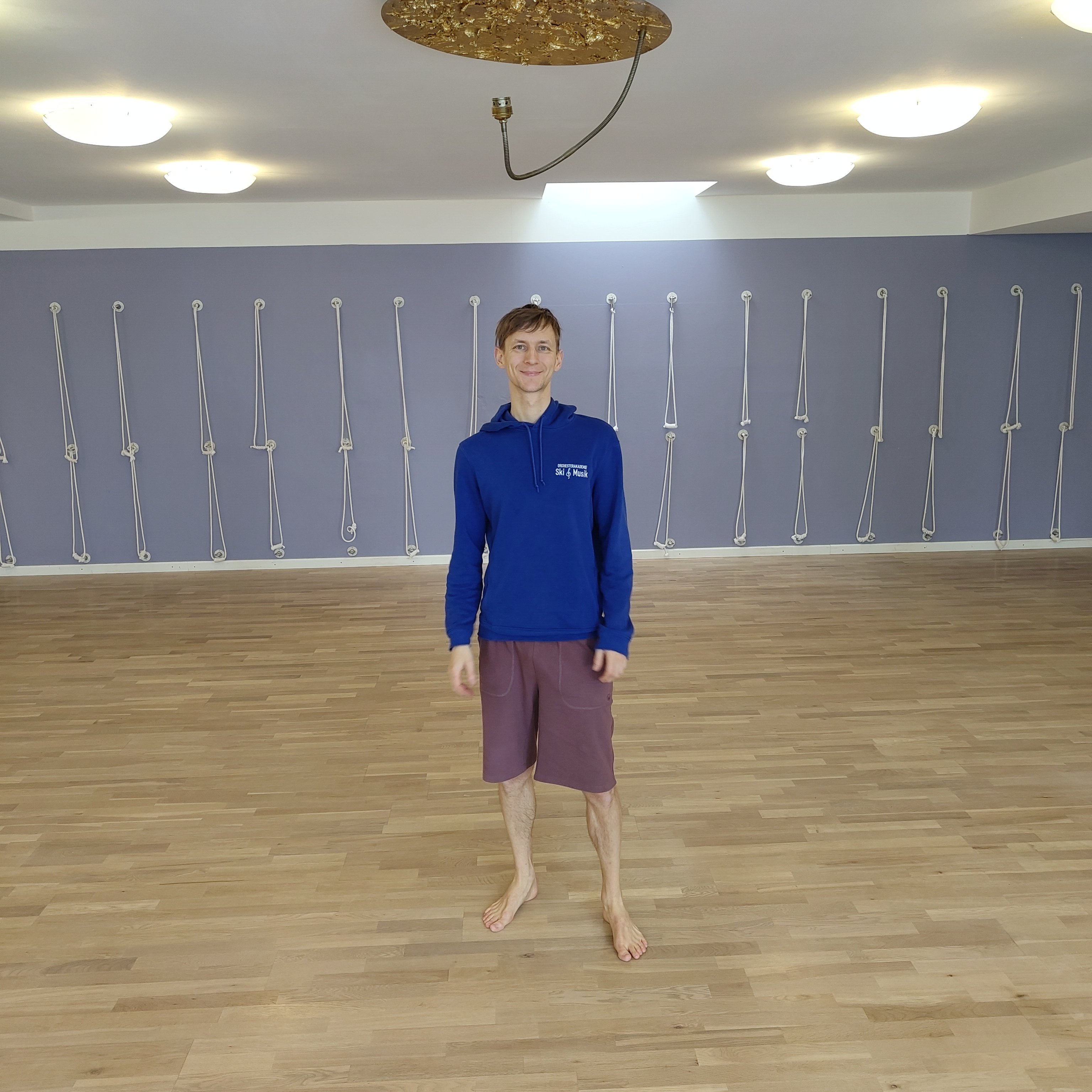 A person standing in the center of a yoga room