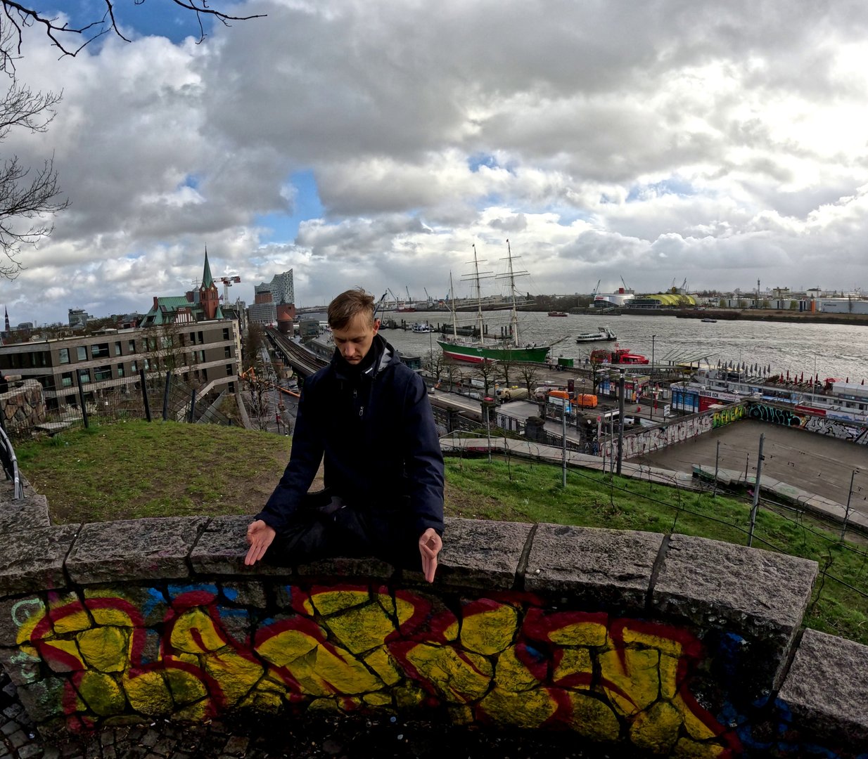 Person in meditation posture in front of Elbphilharmonie.