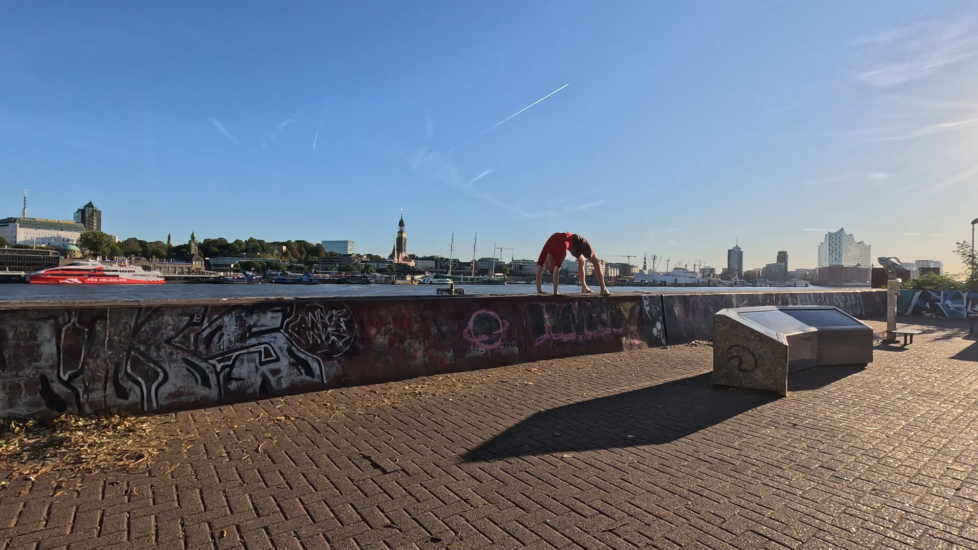 Person in upward bow position in front of Hamburg's skyline